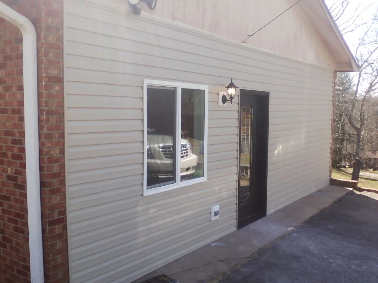 New vinyl siding and entry door on a room addition in Watertown